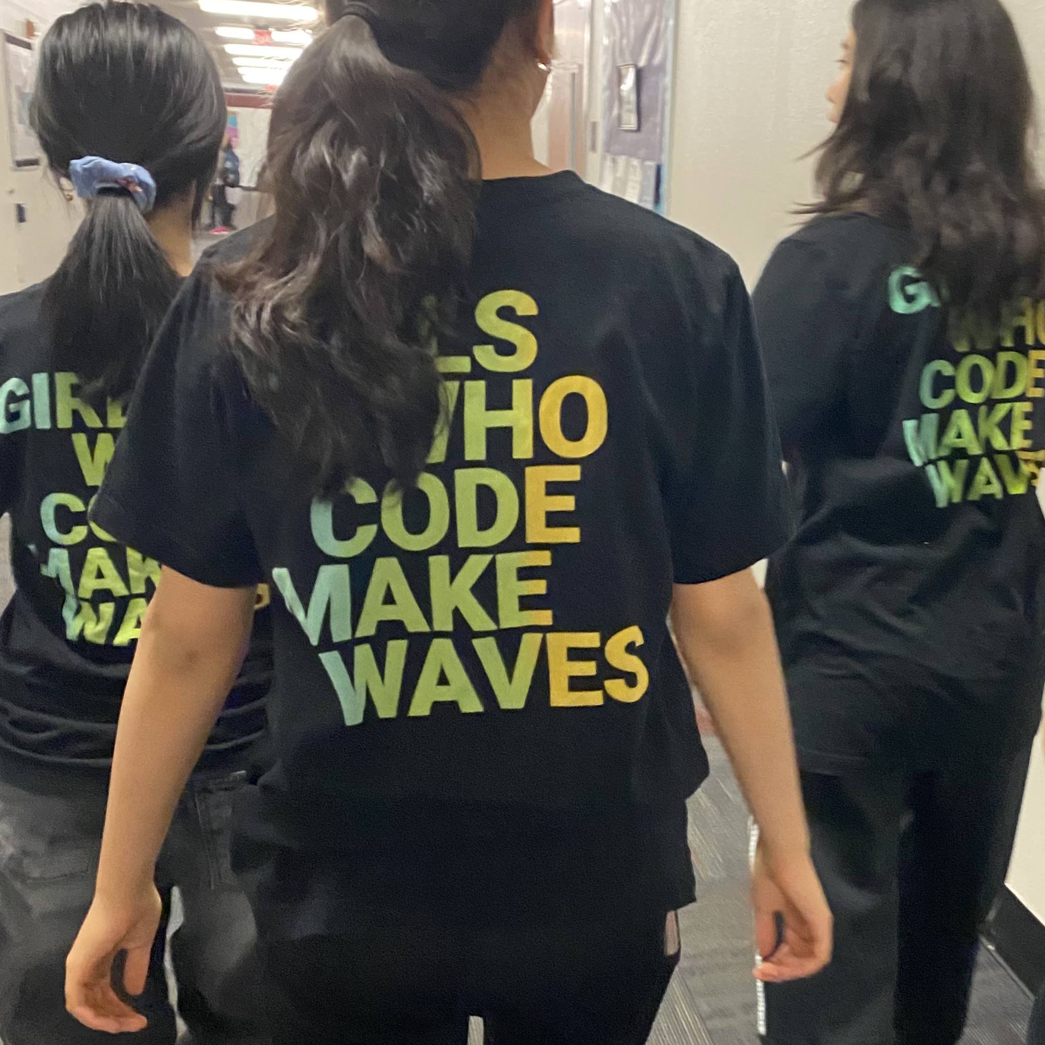 'Girls Who Code Makes Waves' written on the backs of a group of girls' shirts.